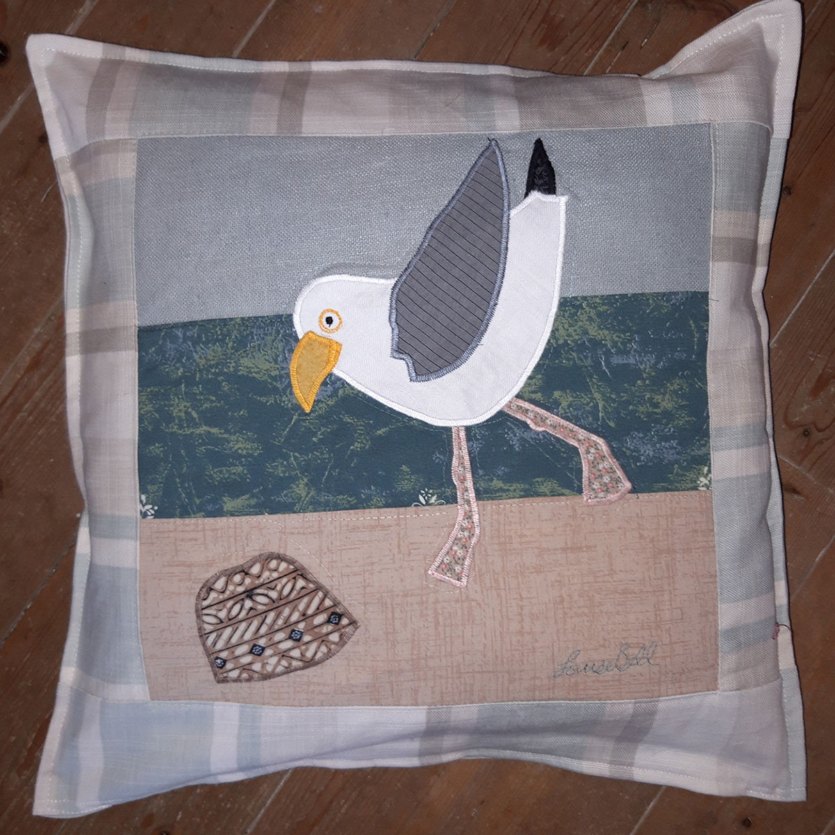 The Sussex Guild Seagull on the beach cushion